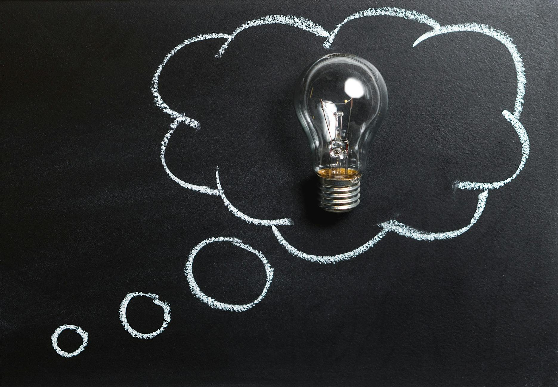 clear online business idea light bulb placed on chalkboard